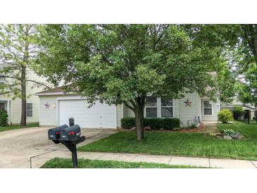 Charming home featuring manicured lawn, a two car garage, and a beautiful shade tree at 6816 Minnow Dr, Indianapolis, IN 46237