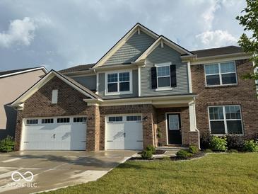Charming two-story brick home featuring a three-car garage, manicured lawn and neutral colored siding at 9407 Casey Rd, Pendleton, IN 46064