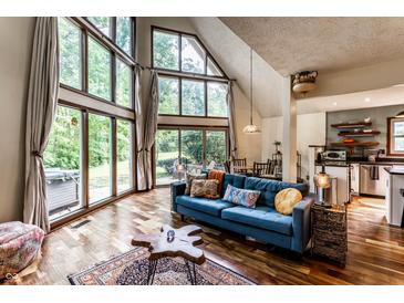 Bright living room features large windows, hardwood floors, and a comfortable blue sofa with decorative pillows at 11544 Crestwood Ct, Indianapolis, IN 46239