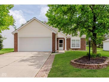 Charming single-story home with brick accents, a two-car garage, and a well-maintained lawn and landscape at 12121 Driftstone Dr, Fishers, IN 46037