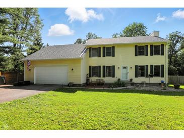 Charming two-story home featuring a well-maintained lawn, attached garage, and classic colonial architecture with black shutters at 1224 S Hunter Rd, Indianapolis, IN 46239