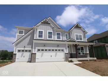 Charming two-story home with a three-car garage and modern farmhouse accents under a blue sky at 12400 French Cattle Way, Noblesville, IN 46060