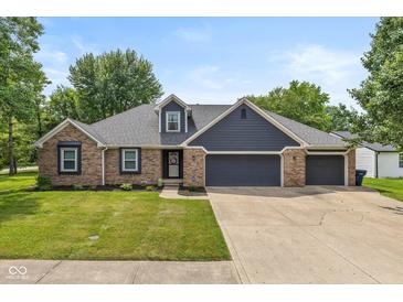 Charming single-story home featuring a well-manicured lawn, brick accents and a spacious three car garage at 12661 Doe Ln, Indianapolis, IN 46236