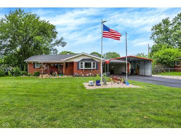 Charming single-story brick home featuring a lush green lawn and American flag at 3038 S Richardt Ave, Indianapolis, IN 46239