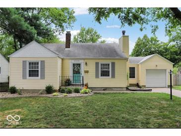 Charming yellow home with gray trim, landscaped yard, and a pop of color on the front door at 5378 Rosslyn Ave, Indianapolis, IN 46220