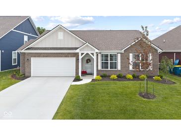 Charming brick home featuring a two-car garage and well-maintained landscaping at 5723 Arctic Run Dr, Noblesville, IN 46062