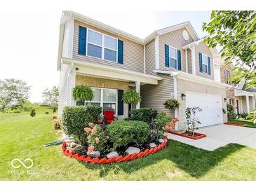 Charming two-story home featuring blue shutters, front porch and an eye-catching landscaped yard at 5859 Edelle Dr, Indianapolis, IN 46237