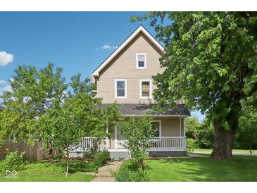 Charming two-story home with a front porch and mature trees in a well-maintained yard at 1129 Trowbridge St, Indianapolis, IN 46203