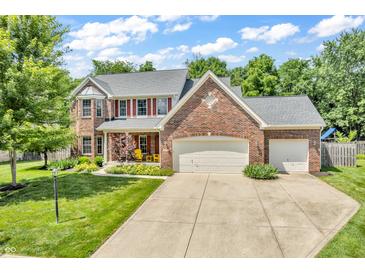 Charming two-story brick home featuring a well-manicured lawn, two-car garage, and inviting front porch at 15075 Windsor Ln, Noblesville, IN 46060