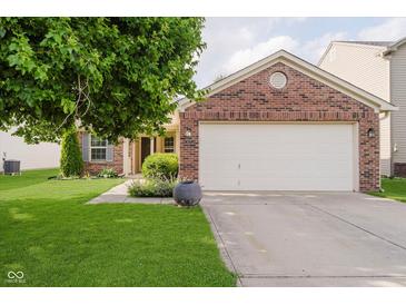 Brick home with a two-car garage, well-manicured lawn, and mature tree in the front yard at 16629 Greensboro Dr, Westfield, IN 46074