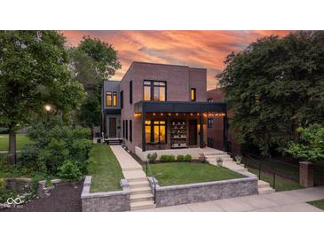 Stunning two-story brick home with covered front porch, stylish lighting, and professionally landscaped front yard at 1905 N Alabama St, Indianapolis, IN 46202