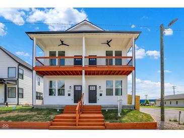 Modern two-story duplex with front porch, black railings and ceiling fans, with a manicured lawn at 2015 Yandes St, Indianapolis, IN 46202