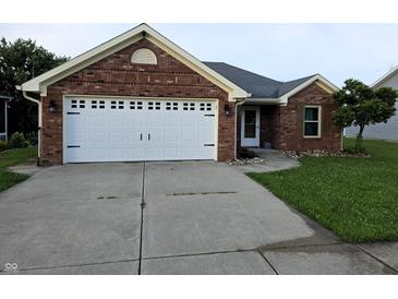 Charming single-story red brick home featuring an attached two-car garage and well-manicured front lawn at 21 Watson Dr, Trafalgar, IN 46181