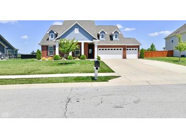 Inviting two-story brick home with a three-car garage, blue siding, and manicured lawn at 21536 Gisborne Dr, Noblesville, IN 46062