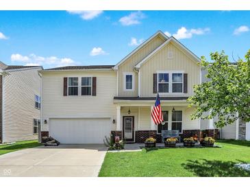Charming two-story home with a well-maintained lawn, an American flag, and an attached two-car garage at 2282 Creekland Dr, Columbus, IN 47201