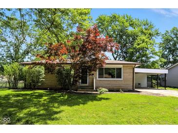 Charming single-story home with well-maintained lawn and mature trees, complemented by a convenient carport at 2811 Beech Dr, Columbus, IN 47203