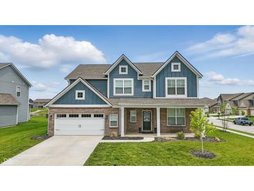 Charming two-story home with brick and blue siding, a well-manicured lawn, and an attached two-car garage at 3650 Merchmont Rd, Bargersville, IN 46106