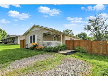 Charming single story home featuring a front porch with hanging plants and a gravel driveway at 405 N Church St, Mooresville, IN 46158