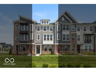 A row of three-story townhouses with varied architectural styles and brick and siding exteriors sit on a well-manicured lawn at 6038 Windsor Dr, McCordsville, IN 46055