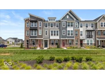 Charming multi-level townhomes boast manicured lawns and eye-catching brick and siding combinations at 6038 Windsor Dr, McCordsville, IN 46055
