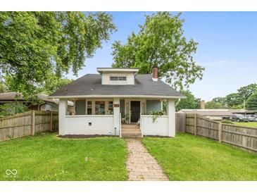 Charming bungalow-style home with a well-manicured lawn and inviting brick pathway at 702 S Keystone Ave, Indianapolis, IN 46203