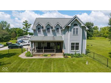 Charming two-story home with a covered porch and lush lawn, perfect for outdoor enjoyment at 7516 S County Road 300 W, Clayton, IN 46118