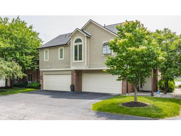Charming two-story condo featuring attached two car garage and brick accents at 7685 River Rd, Indianapolis, IN 46240