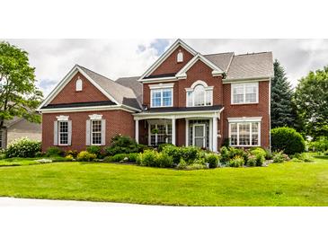 Inviting two-story brick home featuring manicured landscaping and a well-maintained lawn at 10480 Stonegate Dr, Fishers, IN 46040