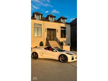 Beautiful brick home with a landscaped front yard, and a modern sports car in the driveway at 16512 Grand Cypress Dr, Noblesville, IN 46060