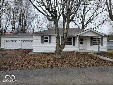 Charming single-story white home with blue shutters, large front yard, and attached garage at 200 S East St, Indianapolis, IN 46204