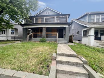 Two-story home featuring a spacious yard, classic architectural details, and covered front porch at 2918 Ruckle St, Indianapolis, IN 46205