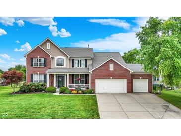 Charming two-story brick home with a well-manicured lawn and a three car attached garage at 564 Gainesway N Dr, Greenwood, IN 46142