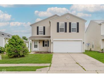 Two-story home features a two-car garage, lawn, and a welcoming front entrance at 7572 Wymm Ln, Ingalls, IN 46048