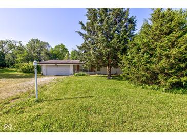 Charming single-story home with an attached garage and a lush green lawn at 10065 E 25Th St, Indianapolis, IN 46229