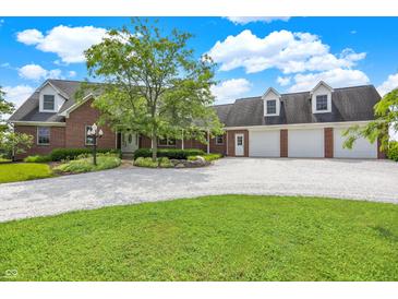 Charming brick home featuring an expansive front yard, dormer windows, three-car garage, and lush landscaping at 11250 N 600 W, Fountaintown, IN 46130