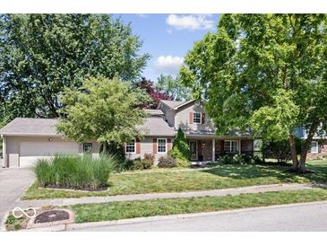 Charming two-story home with attached garage, landscaped yard, and mature trees at 11424 Green St, Carmel, IN 46033