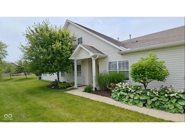 Charming home exterior with lush landscaping, including mature trees and flowering plants at 1201 Fantail Dr, Greenwood, IN 46143