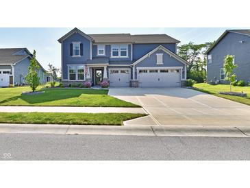 Charming two-story home with a manicured lawn, a two-car garage, and inviting curb appeal at 17390 Tribute Row, Noblesville, IN 46060
