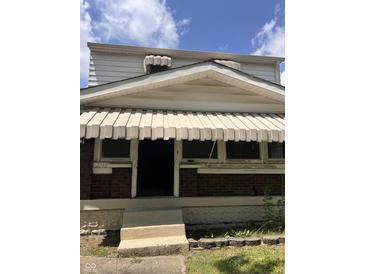 Exterior view of a two-story home showing the front porch with awnings and a brick facade at 2742 Allen Ave, Indianapolis, IN 46203