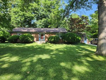 Charming brick ranch home with a lush green lawn and mature trees at 2808 Woodside Dr, Plainfield, IN 46168
