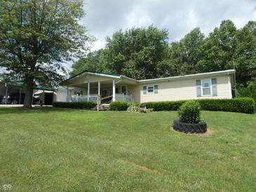 Charming single story home with a covered porch and well-maintained lawn and landscaping at 3310 W State Road 58, Seymour, IN 47274