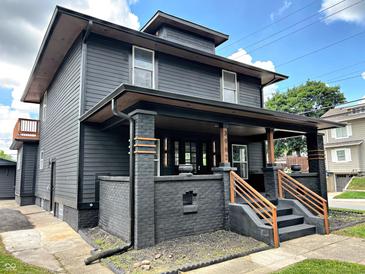 Beautifully renovated two-story home with a covered front porch, black siding and meticulously landscaped yard at 3962 Graceland Ave, Indianapolis, IN 46208