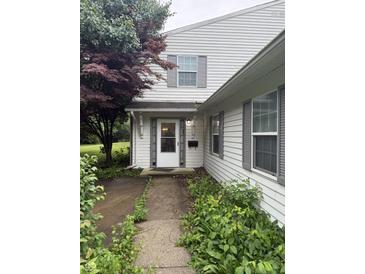 Charming home entrance featuring a white door with sidelights and tidy landscaping at 4404 London Ct, Indianapolis, IN 46254