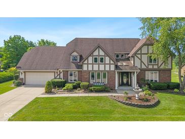 Charming Tudor style home with well-manicured lawn, mature trees, and beautiful landscaping at 625 La Placita St, Greenwood, IN 46143