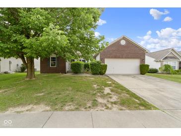 Charming brick home featuring a two-car garage and a well-manicured lawn in a quiet neighborhood at 8778 N Deer Crossing Blvd, McCordsville, IN 46055
