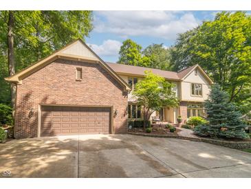 Beautiful brick and siding home with an attached two-car garage and a manicured front yard at 10518 Courageous Dr, Indianapolis, IN 46236