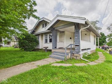 Charming single Gathering home featuring a covered porch, gray trim, and mature landscaping at 1201 Arrow Ave, Anderson, IN 46016