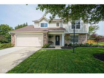Charming two-story home with a well-manicured lawn, brick accents, and attached two-car garage at 13074 Lansdowne Dr, Fishers, IN 46038