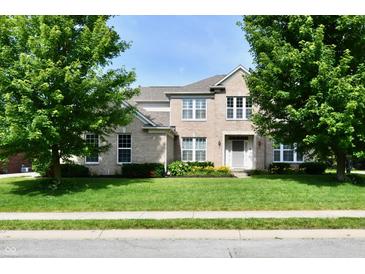 Inviting two-story home with lush green lawn, mature trees, and blooming flowerbeds enhancing its curb appeal at 14082 Brazos Dr, Carmel, IN 46033