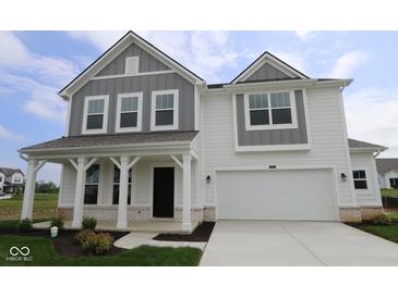 Charming two-story home featuring a covered front porch and a two-car garage at 17110 Cowbell Dr, Noblesville, IN 46060